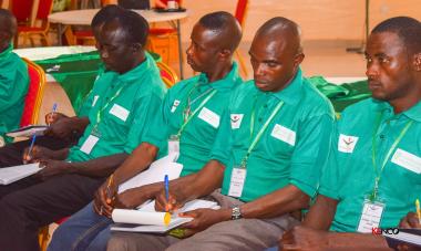 men in green shirts taking notes