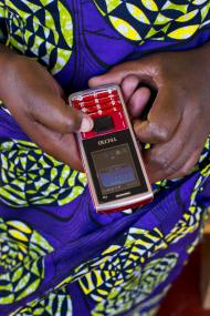 Participant in Rwanda demonstrates using mobile money. Photo credit: Alison Wright