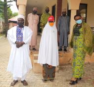 At the Women for Women International - Nigeria office, 6 people pose for the photo, including the Magama Gumau community leader and Buki Onyishi, Nigeria Country Director of our program