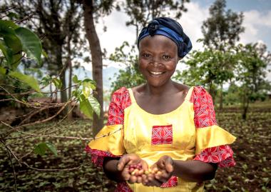 Women holding coffee beans smiling