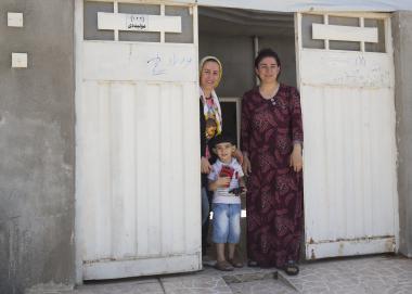 Sheiran, Kabira, and one of Sheiran's sons stand in the doorway of their home. Photo credit: Alison Baskerville