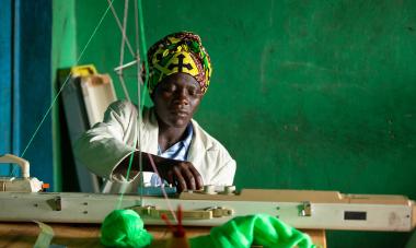 Woman participant from Rwanda program sewing. Photo credit: GiveWith