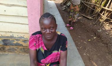 Mulezi, a graduate of the DRC program, smiles at the camera in a pink and black dress