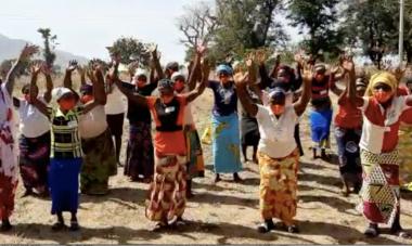 A group of women and their trainers in Jos Plateau State, Nigeria jumping and shouting with their hands in the air, though their faces are covered by masks, to express their gratitude