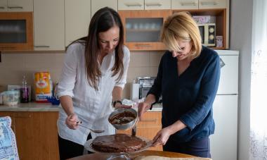 Brita and Amela standing together and mixing batter for a cake; Photo: Hazel Thompson