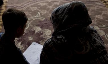 Silhouettes of Shireen and her son reading. Photo credit: Alison Baskerville
