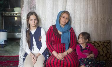 A woman and two young girls sitting next to each other