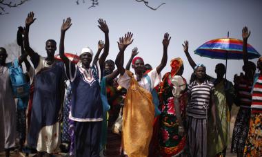 South Sudanese women raise their hands after arriving at the Join Me on the Bridge event