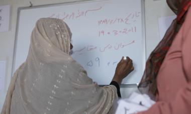 Afghan woman writing on whiteboard