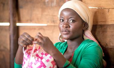 woman weaving pink basket