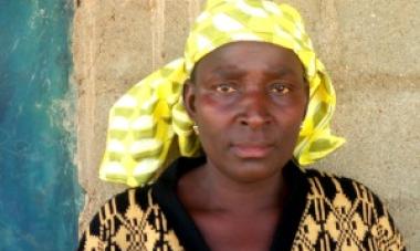 close up of woman in yellow looking at camera