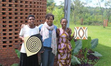 three women holding artwork