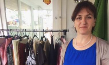 woman pictured in front of clothes