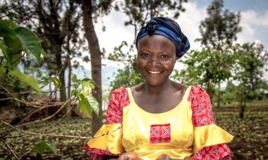 Woman holding coffee beans smiling