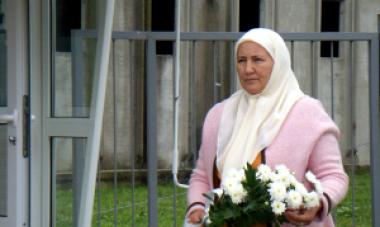 woman standing in cemetery carrying flowers