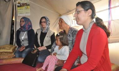 Syrian refugee Attia with daughter while she explains how she fled Syria