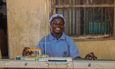 Nigeria - woman smiling at sewing machine