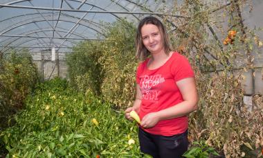 Bosnia - woman in greenhouse showing off veggies