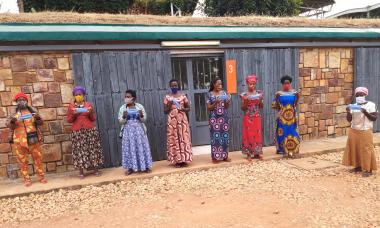 Graduates at the Women's Opportunity Center in Nigeria stand wearing face masks and holding masks that they have made