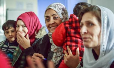 Group of women in Iraq laughing. Photo credit: Emily Kinskey