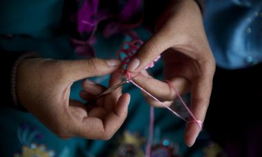 Woman's hands crocheting/knitting. Photo credit: Rada Akbar
