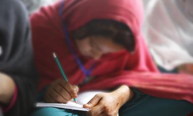woman writing closeup red headscarf
