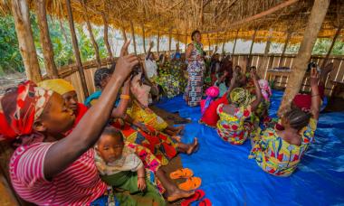 women sitting in group with a few raising their hands to ask a question