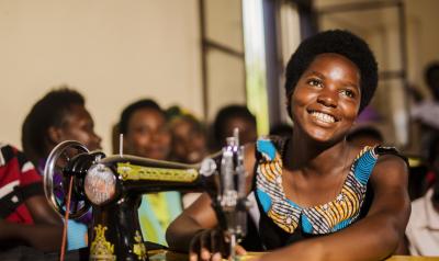 Rwanda - woman at sewing machine smiling 