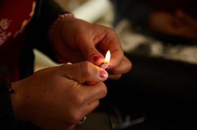 A woman from the Iraq program holds a small flame in her hands. Credit: Women for Women International