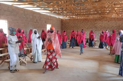 Many women gather in the graduation clothes of red to celebrate their graduation from the program